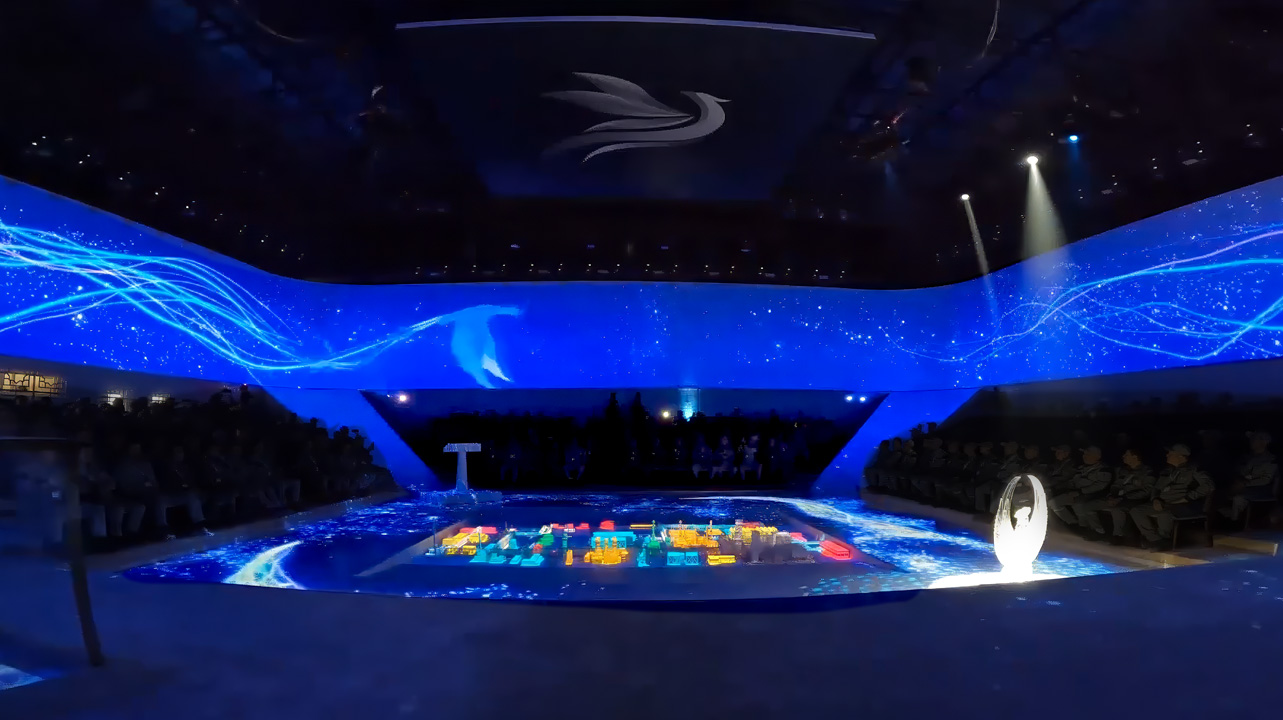 Vast industrial hall illuminated by a 360-degree projection mapping presentation.